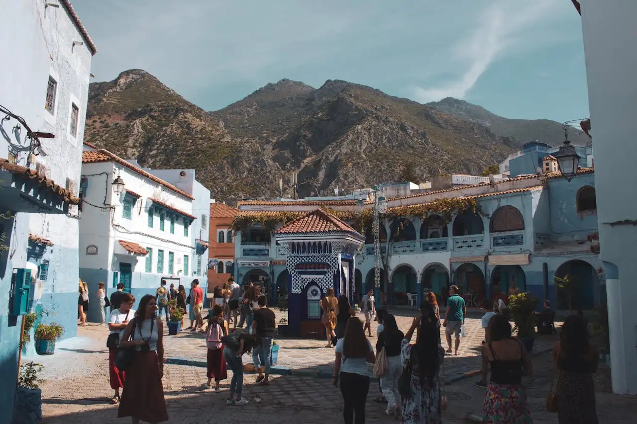 Narrow blue-painted lane in Chefchaouen with a traveler walking calmly in daylight