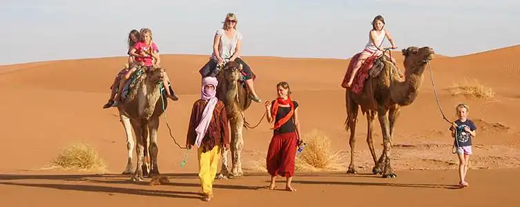 Family camel ride Sahara dunes sunset Merzouga